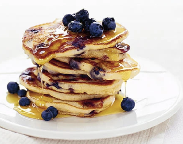 Stack of blueberry pancakes with powdered sugar